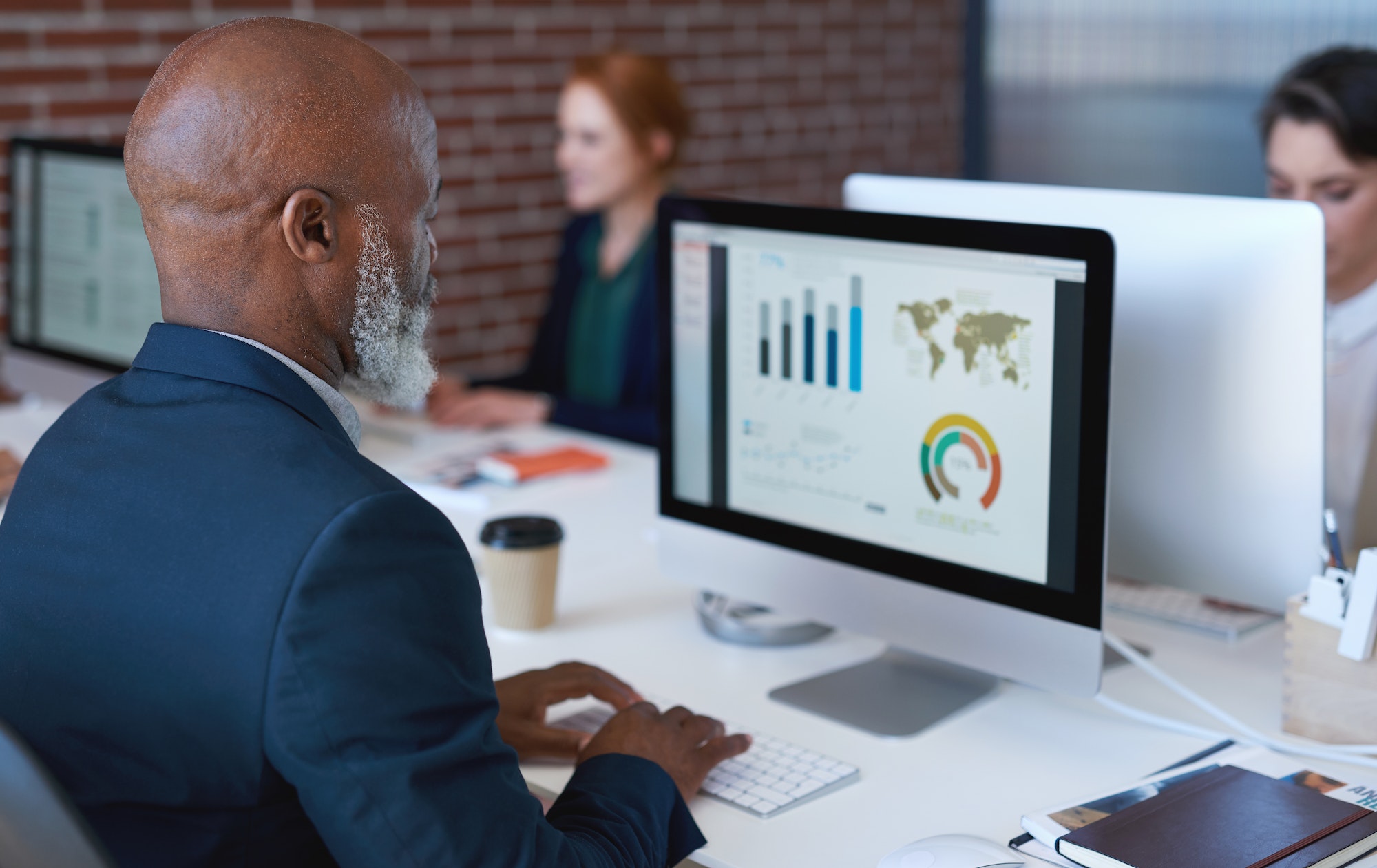 African american businessman using computer with financial graph data on screen business people wor