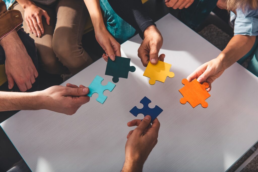 Teamwork of partners connect puzzle pieces as integration and startup