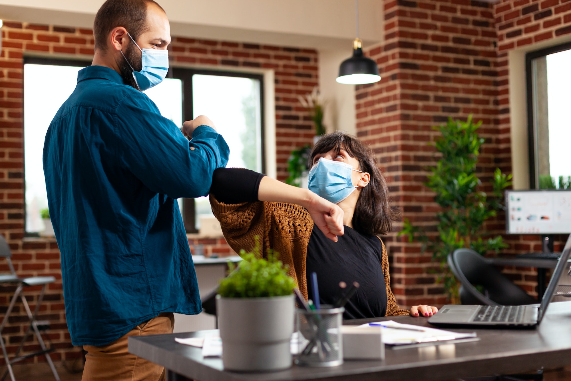 Workmates with medical protection face mask to prevent infection with covid19