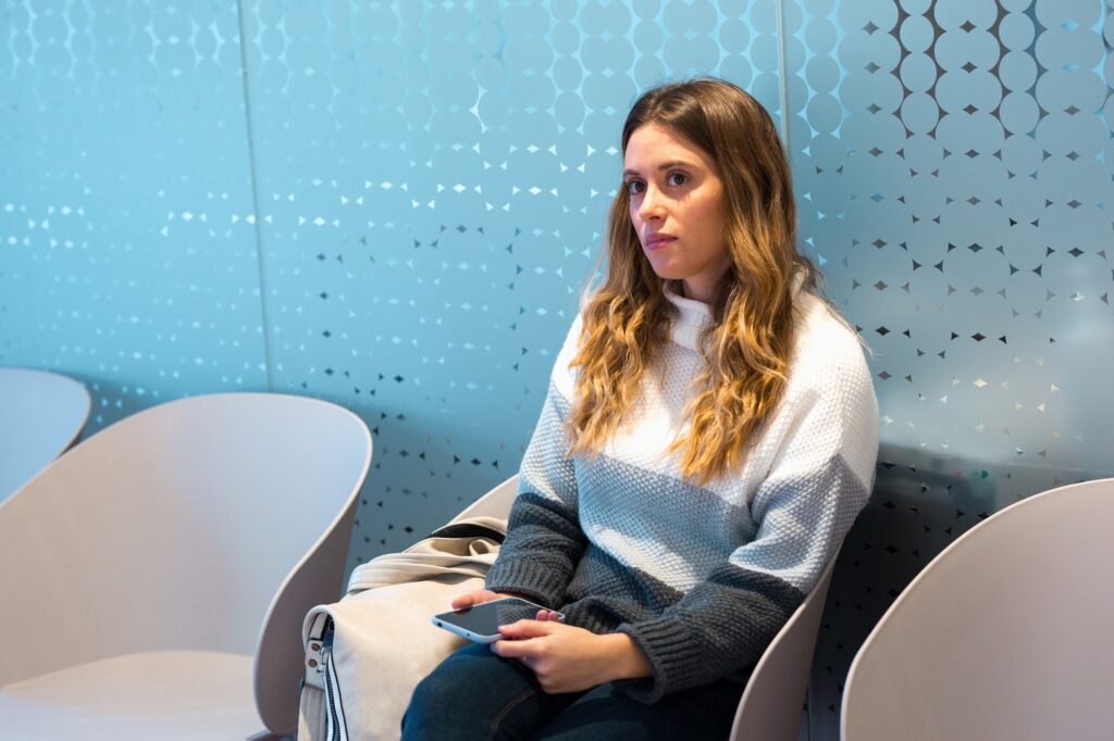 Young woman waiting in waiting room of private medical center